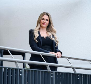 Laura Opferkuch, CEO von Hosta, steht an einem Treppengeländer.